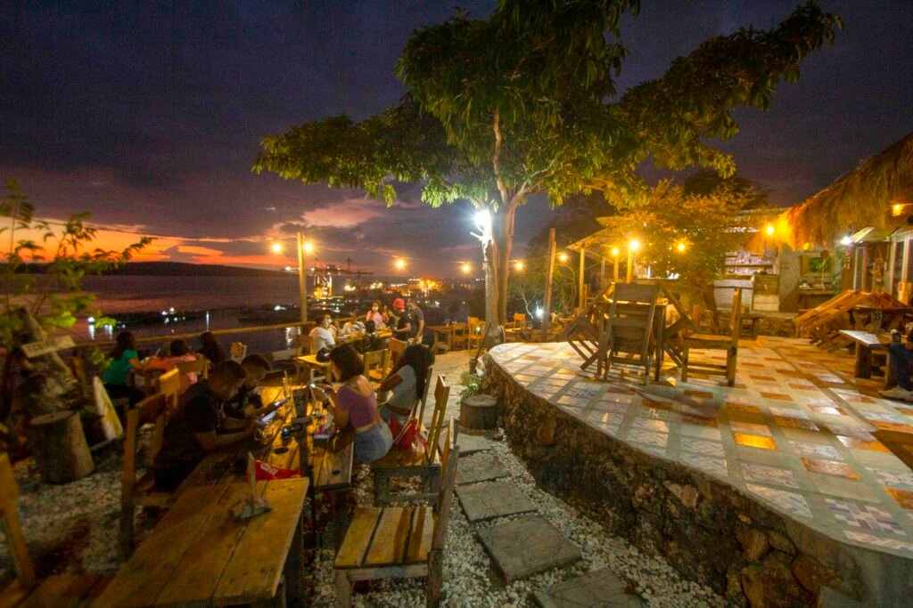 Lampu meja dan area duduk Kafe Tebing saat senja