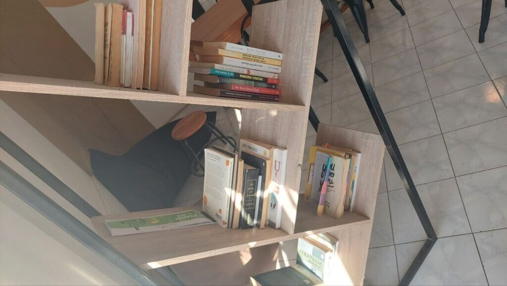Rak buku di Kopi Papa Ganteng Kupang