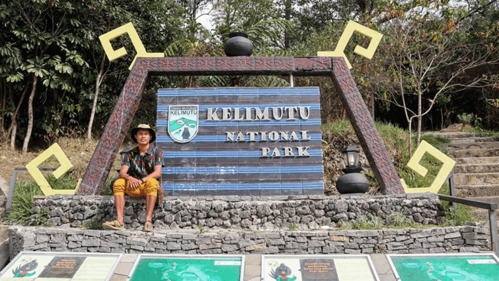 Pengunjung di depan penanda Taman Nasional Kelimutu