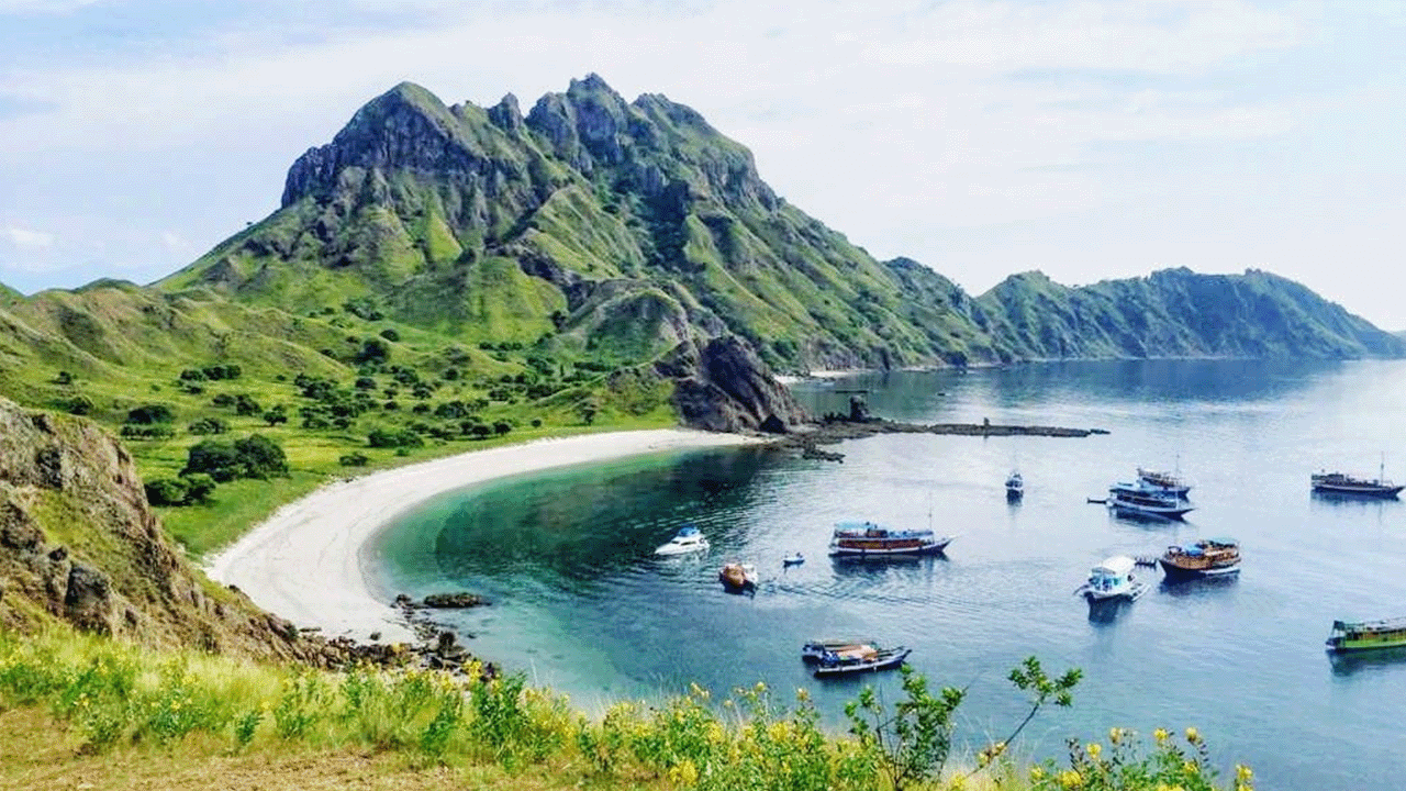 Teluk dan perbukitan Pulau Padar dengan beberapa kapal di perairan