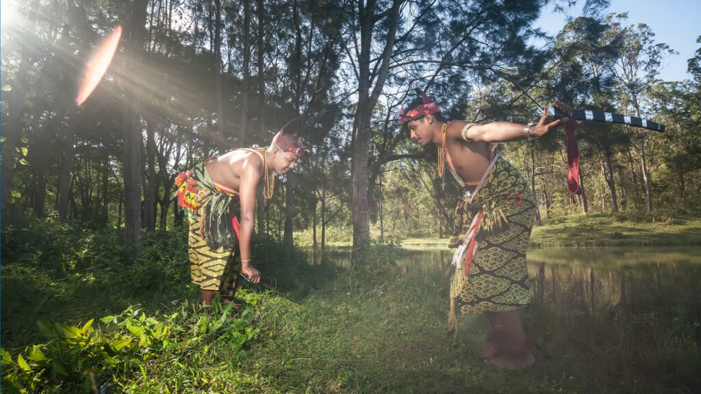 Para peserta berbusana tradisional menari di area pepohonan