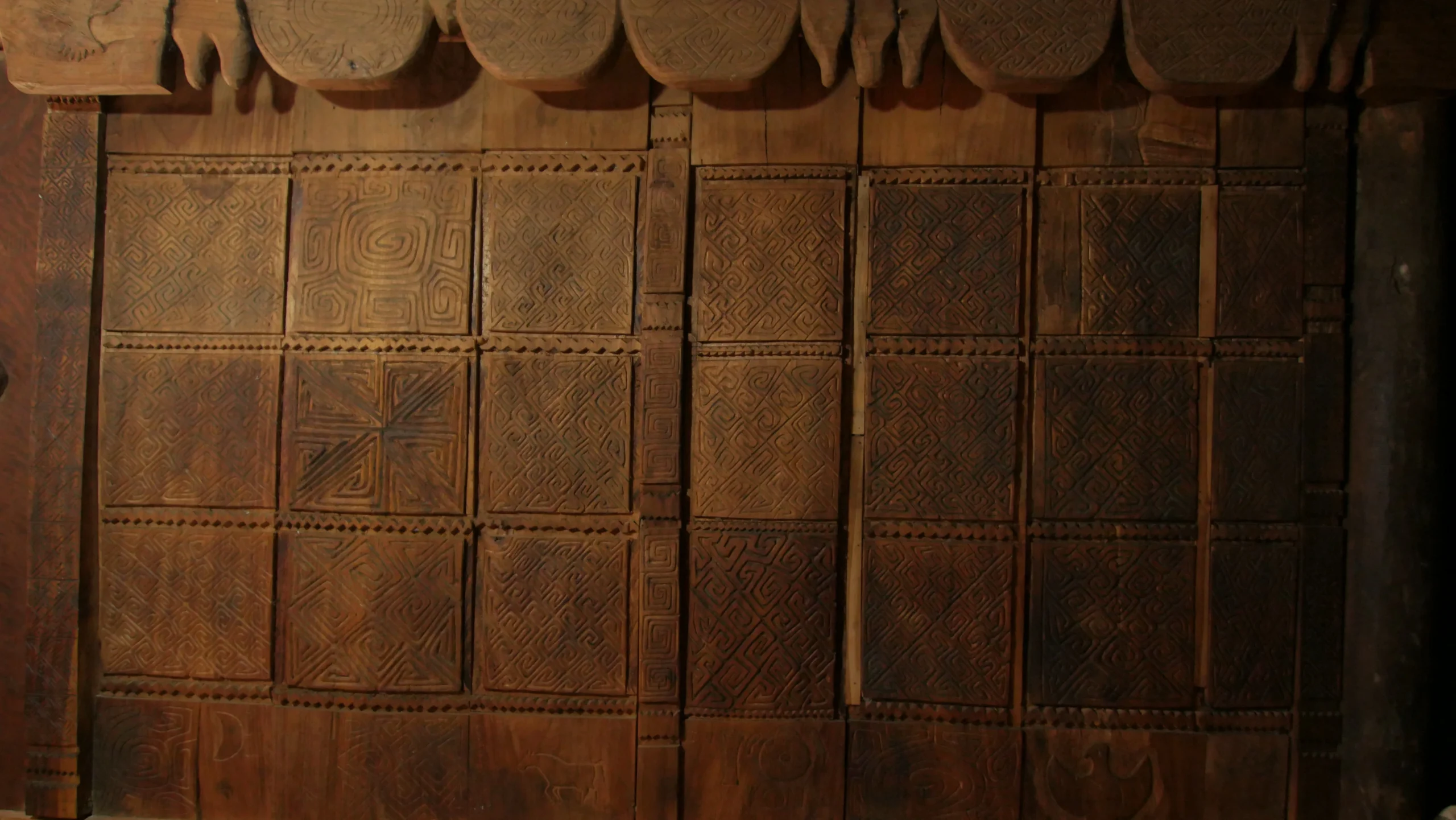 Panel kayu berukir di rumah adat Dirun