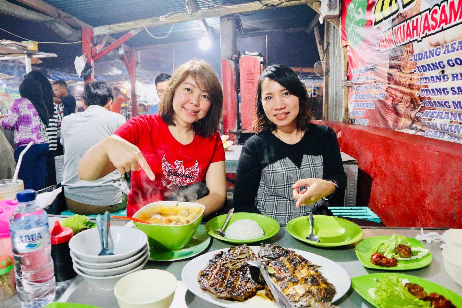 Dua pengunjung di meja hidangan warung seafood Kampung Solor