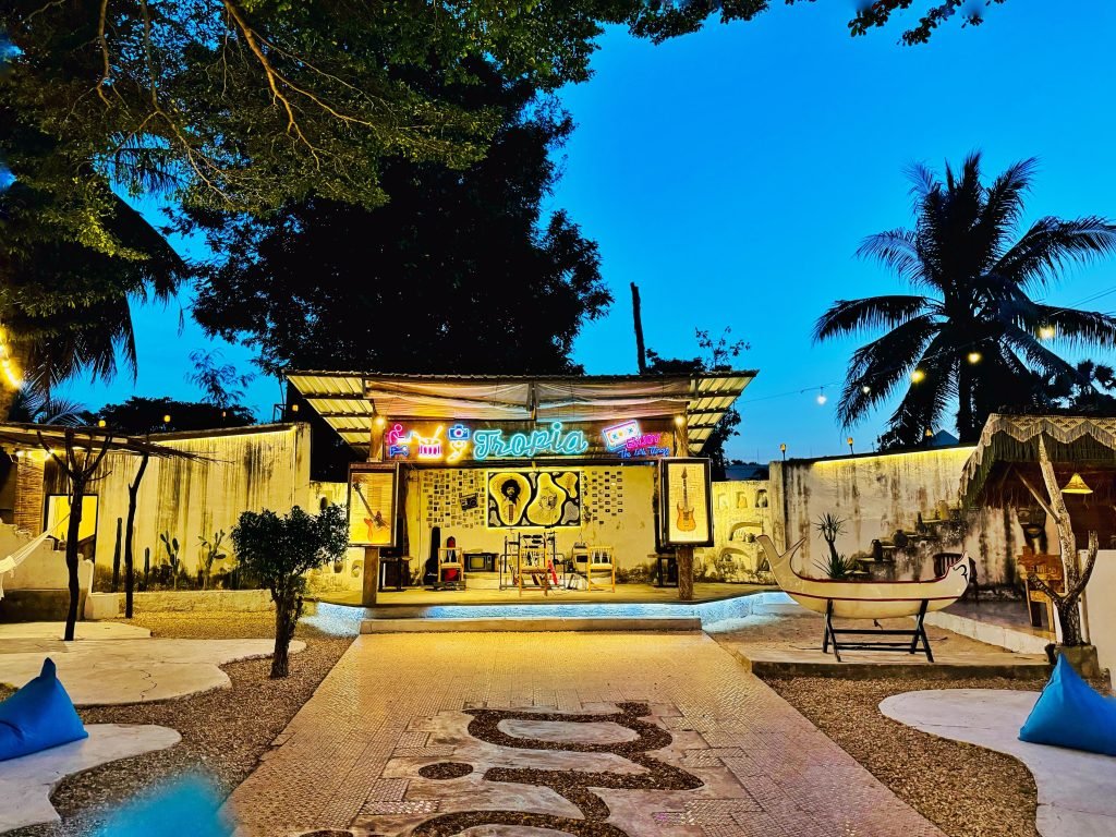 Tampak depan Tropia Café dengan pepohonan dan lampu