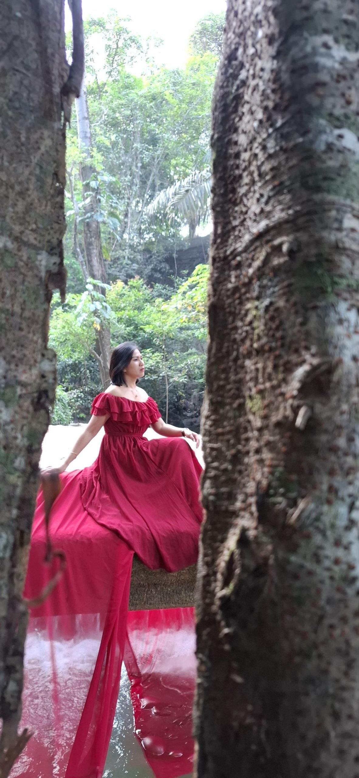 Busana merah di antara pepohonan Oenesu