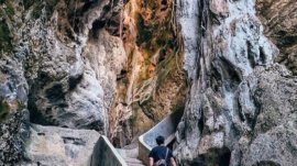 Pengunjung menyusuri jalur di antara dinding batu Goa Batu Cermin, Labuan Bajo