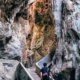 Pengunjung menyusuri jalur di antara dinding batu Goa Batu Cermin, Labuan Bajo